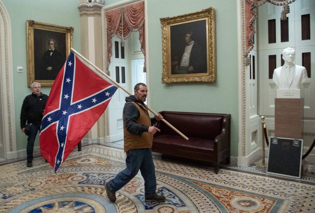 A protester carries the Confederate Flag inside Capitoll Hill building.